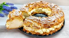 a bundt cake with powdered sugar on top and blue flowers in the background