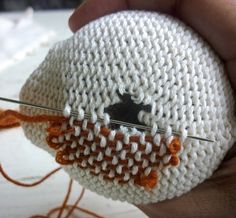 someone is knitting something with scissors in their hand and it looks like an eyeball