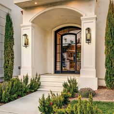 an entrance to a home with white walls and columns