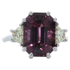 This unforgettable Spineland Gemstone ring will leave a long-lasting impression of elegance and sophistication, making it the ultimate treasure for a birthday or anniversary occasion. This beautiful, brightly polished 18k white gold cocktail ring 7.17 carat Emerald cut brilliant-cut Spinel that exhibits an incredible Purple Pink, unlike any other stone. 2 glittering trapezoid diamonds this ring in a spectacular show of fire and extravagance amplifying the vibrancy of the tourmaline. Total diamond weight: 0.76 carats. Emerald Cut Diamond Ring, Gold Cocktail Ring, Gold Cocktail, Emerald Cut Diamond, Emerald Cut Diamonds, Cocktail Ring, Cocktail Rings, Gemstone Ring, Emerald Cut