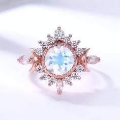 an opal and diamond ring is displayed on a white surface