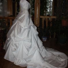 a white wedding dress sitting on top of a wooden floor