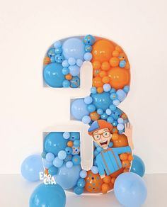 the letter e is made up of balloons and blue balls with an image of a clown on it