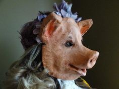 a cow mask with flowers on it's head is shown in front of a wall