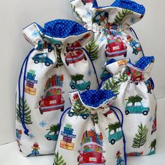 three drawstring bags with cars and trees on them, one has blue handles