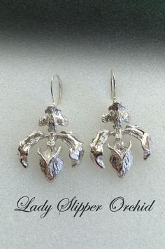 These Lady Slipper earrings are inspired by Cypripedopodeae, which is a subfamily of orchids commonly known as  Lady Slipper orchids. They are characterized by the slipper-shaped pouches of the flowers. The pouch traps insects so they are forced to climb up past the staminode, behind which they collect or deposit pollinia, thus fertilizing the flower. There are approximately 165 species in this subfamily. My rendition is cast in sterling silver by the lost wax process, and is 7/8 inch wide and o Lady Slipper Orchid, Lady Slipper, Orchid Earrings, Jewelry Lookbook, Silver Accessories, Lost Wax, Silver Drop Earrings, Jewelry Inspo, Flower Jewellery