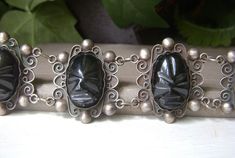 Vintage Mexican sterling silver Aztec mask black onyx panel bracelet. Wonderful, ornate made in Mexico sterling silver bracelet with large black onyx gemstone faces/masks made to look like Aztec warriors. Signed "Silver Mexico", this may date from the 60's or 70's.  Very wide, at 1.4".  Length is 7.8" and fits an average wrist. Clasp is a slide lock and works fine. There is some oxidization to the sterling, but I will leave it up to the buyer to wear as is or to polish it.  Personally, I like it Unique Black Sterling Silver Bracelets, Adjustable Black Bracelet For Collectible, Adjustable Black Bracelet For Collectors, Vintage Black Carved Jewelry, Antique Black Bracelets As Gift, Collectible Black Bracelet Jewelry, Aztec Mask, Aztec Bracelet, Aztec Warrior