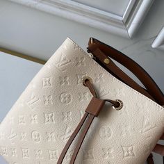 Embossed Monogram Empreinte leather brings a sophisticated feel to the NéoNoé MM bucket bag with its leather drawstring and gold-color eyelets. The body-friendly design and light-weight construction mean it’s comfortable to carry, by hand with the removable top handle or over the shoulder and cross-body, thanks to it detachable and adjustable strap. Detailed Features 10.2 x 10.2 x 6.9 inches (length x Height x Width) Cream and Caramel Embossed Monogram Empreinte grained cowhide leather Cowhide-l Lv Body Bag Louis Vuitton, Louis Vuitton Metallic Bag, Néonoé Mm, Louis Vuitton Neonoe, Mean It, Vuitton Bag, Exclusive Designs, Cowhide Leather, Leather Trims