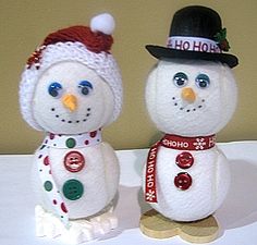 two snowmen with hats and scarves on their heads