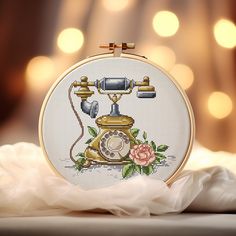 an old fashioned phone with roses on the front and side is shown in this embroidery pattern