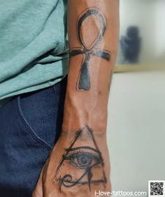 a person with a tattoo on their arm holding an eye and an egyptian symbol in his hand