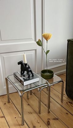 a glass table with a candle on it and a dog figurine next to it