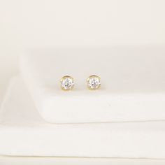 Tiny round cz earrings, Minimalist tiny Dainty Stud Earrings, Diamond studs, Dainty cz studs, Gold Post earrings, Delicate earrings Simple and classic beautiful fine white cz one pair of studs deliver brilliant shine and sit comfortably snug to your ears. A push backing butterfly keeps the earring securely in place. These silver stud earrings are completely unisex and they would also work great in a secondary piercing. D E T A I L S * Available in sterling silver or Crafted in 22 K Gold plated . Earrings Diamond Studs, Stud Earrings Diamond, Half Bezel, Studs Gold, Dainty Studs, Earrings Diamond, Earrings Simple, Cz Earrings, Earrings Minimalist