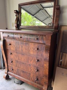 an old dresser with a large mirror on it's top and drawers in the bottom