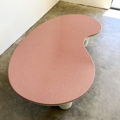 a pink table sitting on top of a cement floor