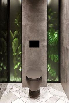 a bathroom with a toilet and green plants on the wall behind glass doors that say new posts