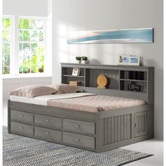 an image of a bed with drawers in the middle and a painting on the wall behind it