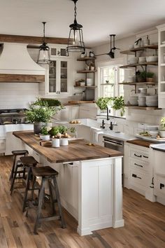 a kitchen filled with lots of white cabinets and wooden counter tops next to a stove top oven