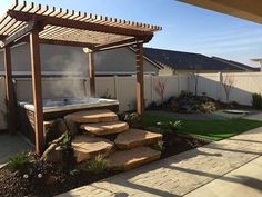 an outdoor hot tub in the middle of a yard with steps leading up to it