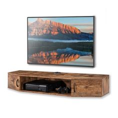 a flat screen tv sitting on top of a wooden shelf