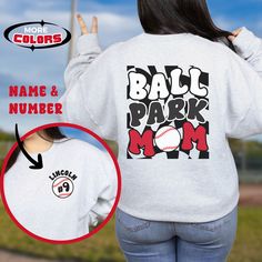 Our customizable Ballpark Mom sweatshirt features a groovy, retro vibe. The back of this super comfy baseball sweater boasts groovy text set against a trendy checkerboard background. Customize the front pocket area with your player's name and jersey number.  ** SWEATSHIRT FEATURES ** This unisex heavy blend crewneck sweatshirt is made from polyester and cotton and is created for comfort. .: Medium-heavy fabric (8.0 oz/yd² (271.25 g/m .: Loose fit .: Runs true to size .: 50% cotton, 50% polyester Baseball Season Fan Apparel Sweatshirt With Graphic Print, Baseball Season Graphic Print Sweatshirt, Relaxed Fit Graphic Print Sweatshirt For Baseball Season, Baseball Season Sports Fan Sweatshirt With Graphic Print, Game Day Baseball Season Graphic Sweatshirt, Baseball Season Game Day Graphic Sweatshirt, Baseball Season Graphic Print Sports Fan Sweatshirt, Collegiate Baseball Season Sweatshirt With Graphic Print, Sports Fan Baseball Sweatshirt With Graphic Print