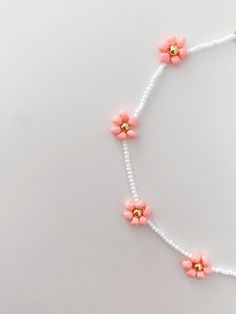 a necklace with pink flowers and white beads