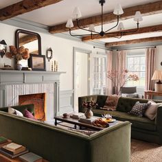 a living room filled with furniture and a fire place under a chandelier above a fireplace