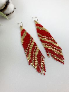 "Red and gold boho seed bead earrings, beaded earrings, fringe abstract seed bead earrings Length 5\" including ear wire Width 1\" Made with best quality Japanese seed beads, and 24k gold dipped seed beads Lightweight and unique extravagant style - designed and made by Luba Ro Colors used - 24k gold, shimmering gold and red Select closure earwires leverbacks clip-ons for non pierced ears" Handmade Gold Beaded Earrings For Christmas, Festive Gold Beaded Earrings, Red Bohemian Beaded Earrings With Gold Beads, Bohemian Red Beaded Earrings With Gold Beads, Gold Beaded Christmas Earrings, Red Gold Beaded Drop Earrings, Gold Beaded Earrings For Christmas, Red Bohemian Earrings For Christmas, Gold Festive Earrings With Tiny Beads