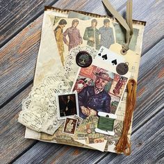 an old book with lace and pictures on it sitting on a wooden table next to a pair of scissors