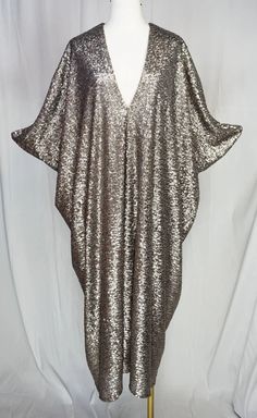 Be the life of the party in this Gunmetal Nouveau Sequin Caftan! With matte light gold, silver and bronze sequins, this luxurious and glamorous caftan will make you shine. Cozy up in the bamboo jersey lining while looking oh-so-fabulous. A perfect mix of comfort and style, this caftan is a must-have addition to your Jennafer Grace collection. Festive Gold V-neck Kaftan, Summer Party Sequined Kaftan, Summer Party Sequin Kaftan, Sequined Summer Evening Kaftan, Summer Party Kaftan With Sequins, Sequin Kaftan For Evening And Summer, Festive Metallic Sequin Dress, Gold Embellished Evening Kaftan, Sequined Kaftan For Evening In Summer