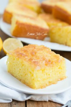 a slice of lemon cake on a white plate next to some slices of lemons