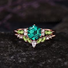 a ring with an emerald and white topazte surrounded by diamonds on a rock