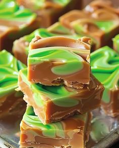 several pieces of candy sitting on top of a metal tray covered in green and brown icing