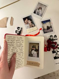 a hand holding an open book with photos on it