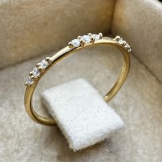 a gold ring with five diamonds on it