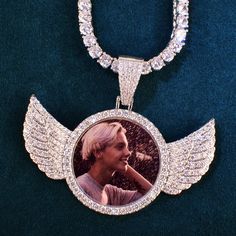 Looking for a fashionably sweet and unique gift? Or maybe you're just treating yourself to a little something special? Our Round Angel Wing Photo Necklace is perfect for any angel in your life. It's also a great way to keep your loved ones close to your heart.This beautiful gold plated necklace comes with a photo pendant that is adorned with cubic zirconia stones. It's the perfect way to show off your style and keep your loved ones close to your heart. The pendant is also available in a variety of chain lengths, so you can choose the perfect one for you. So go ahead and treat yourself to something special today. You deserve it! PRODUCT DETAILS: Metals Type: Copper Customized Type: Photo Necklace Type: Chains Necklaces Gender: Unisex Material: Cubic Zirconia Compatibility: All Compatible Pe Hip Hop Jewelry Chains, Photo Necklace, Photo Pendant, Chains Necklaces, Hip Hop Jewelry, Gold Plated Necklace, Custom Necklace, Something Special, Men Necklace