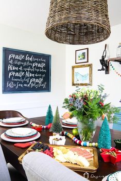 a dining room table decorated for christmas with plates, cups and bowls on the table