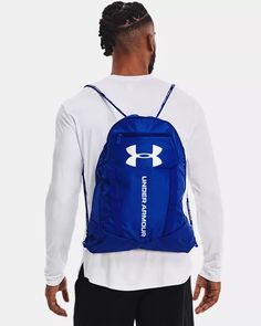 a man wearing a blue and white under armour backpack with an under armour logo on the back