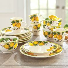 a table topped with plates and cups filled with lemons