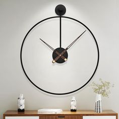 a clock is hanging on the wall above a dresser