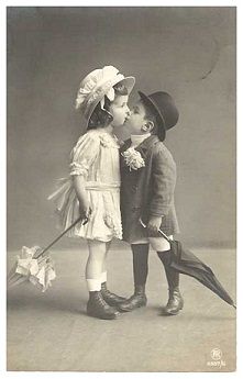 an old photo of two children kissing each other