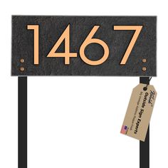 a metal sign with the number 1847 on it and a tag attached to it