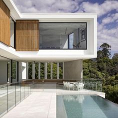 an outdoor swimming pool in front of a modern house