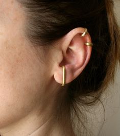 Modern, minimalist ear cuff set of two. No piercing needed. They are made from 3mm half-rounded brass wire. Brass is an alloy of copper and zinc - the proportions of the two differ to create different kinds of brass that range in degree of yellow-color. If you have a nickel allergy, you are very unlikely to be allergic to brass since there is no nickel in it at all. The cuffs are cut and textured by hand to a mat finish. Choose the combo you like and wear them all day long. See the matching earr Conch Cuff, Minimalist Ear Cuff, Helix Ear, Huggie Earring, Wrap Earrings, Dope Jewelry, Pierced Jewelry, Beaded Hoops, Gold Brass