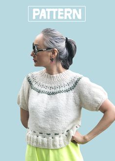 an older woman with her hands on her hips wearing sunglasses and a knitted sweater