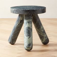 a black and white marbled stool sitting on top of a wooden floor