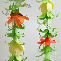 three paper christmas trees hanging from the ceiling