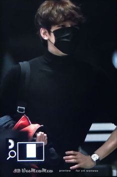 a man wearing a black mask and carrying a red bag