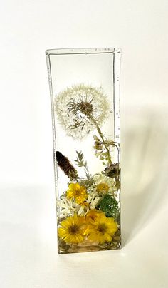 a glass vase filled with yellow and white flowers