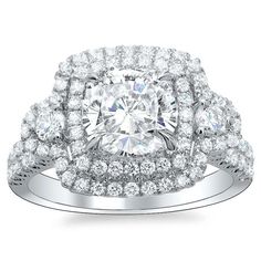 a cushion cut diamond with double halos on the shoulders and sides, surrounded by round brilliant diamonds